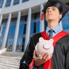 student holding piggy bank.