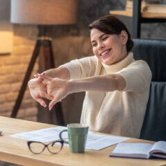 Joyous young woman cracking her knuckles at the desk