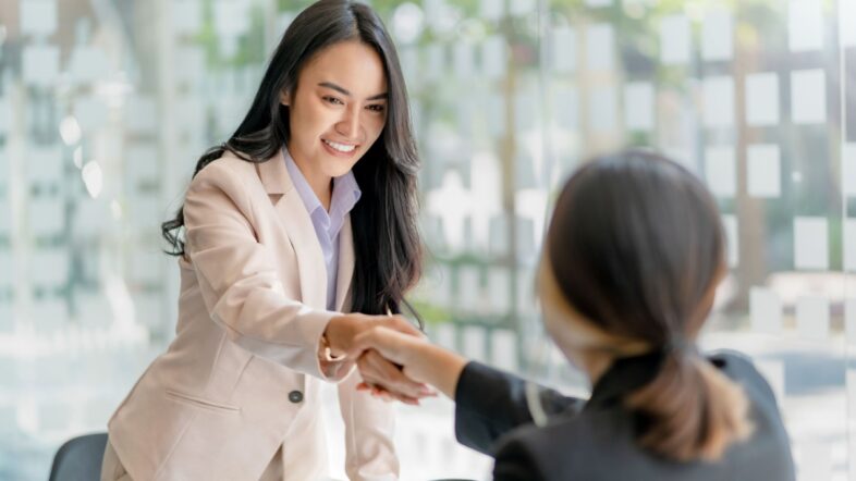 Asian businesswoman shaking hands to congratulate success.