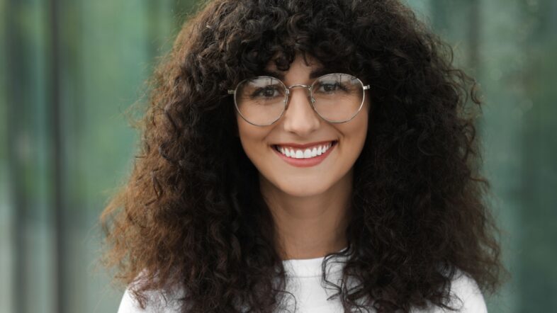 Portrait of beautiful woman in glasses on blurred background.